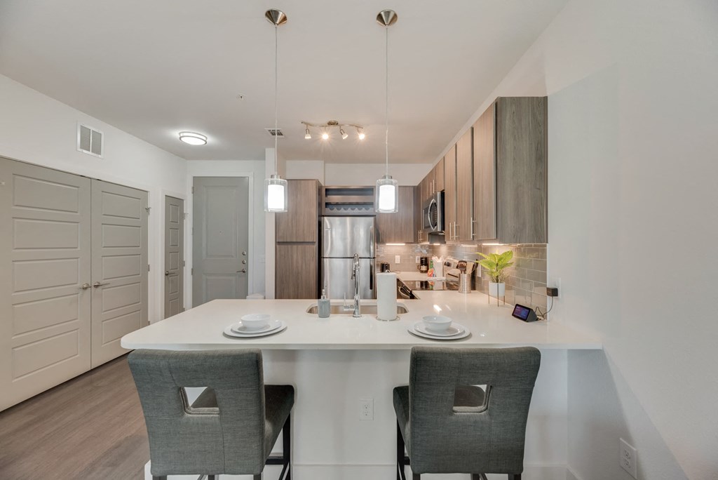 a kitchen with a large island and two chairs
