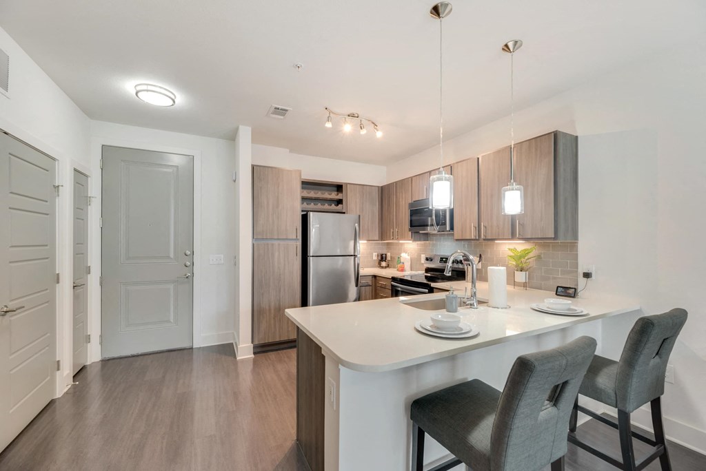 a kitchen with a large island and a stainless steel refrigerator