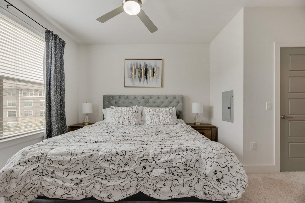 a bedroom with a large bed and a ceiling fan
