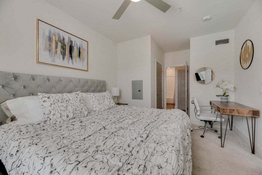 a bedroom with a bed and a desk with a chair