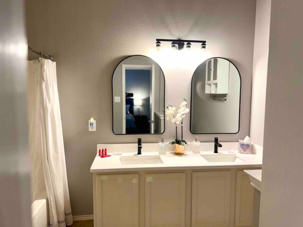 a bathroom with two sinks and two mirrors