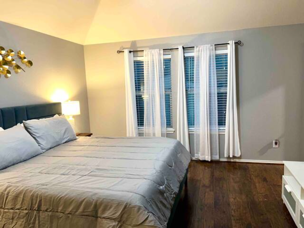 a bedroom with a large bed and a large window