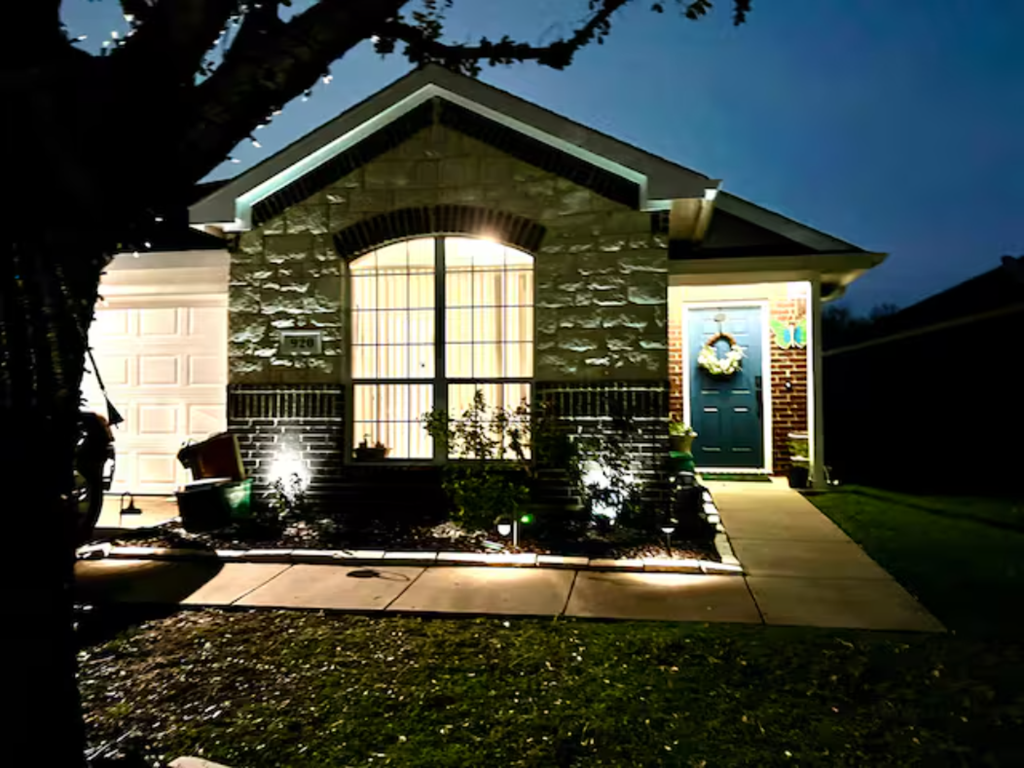 the front of a house at night with the light on the front door