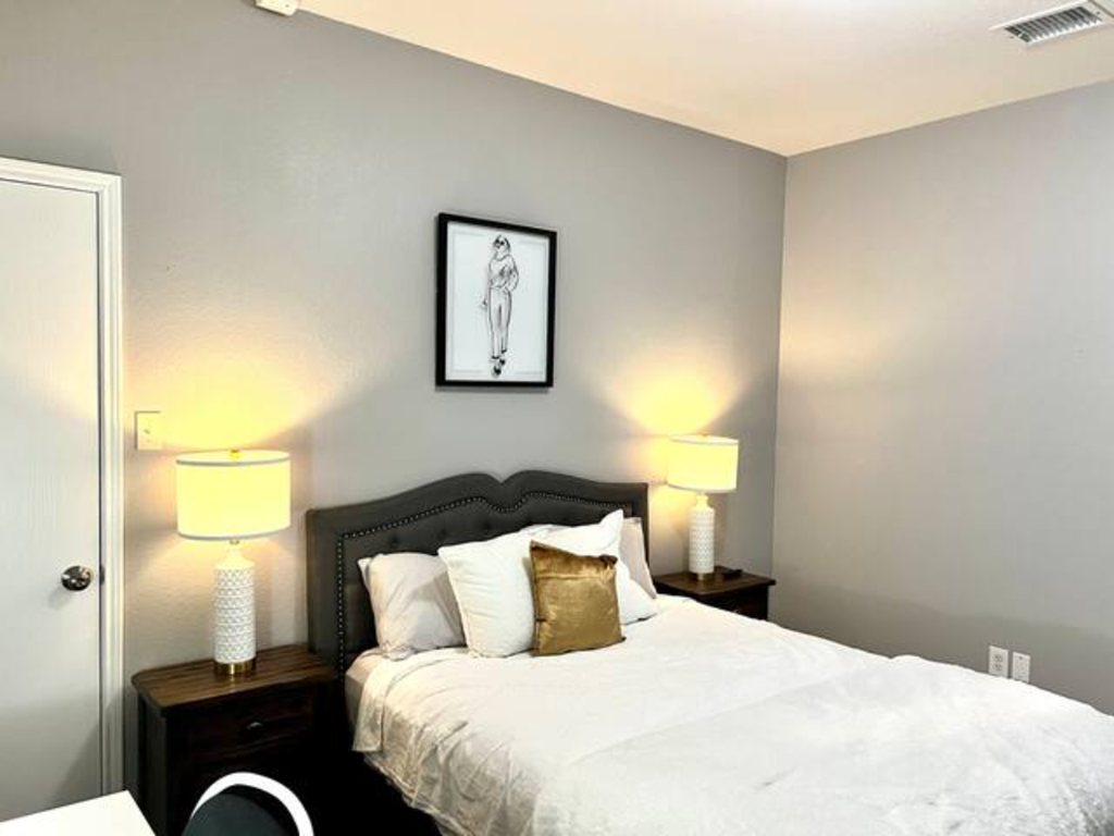 a bedroom with a bed and two lamps