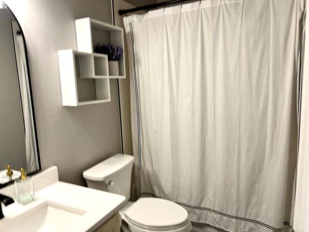 a bathroom with a white shower curtain and a toilet