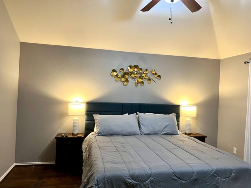 a bedroom with a blue bed and a ceiling fan