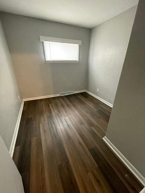 A room with wooden flooring and a window.