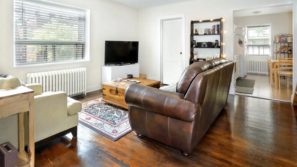 a living room with a leather couch and a tv