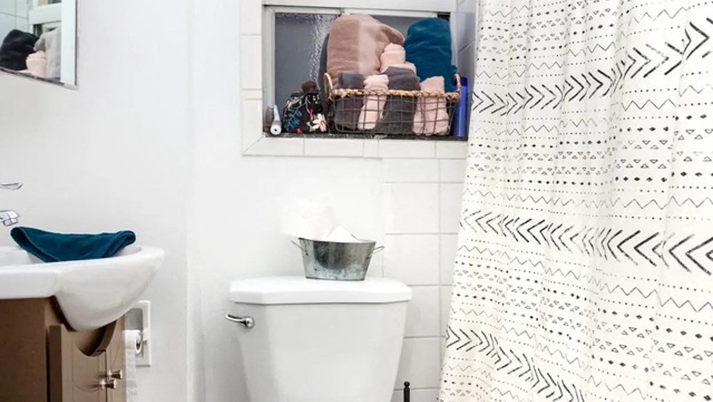 a white bathroom with a shower curtain and a toilet