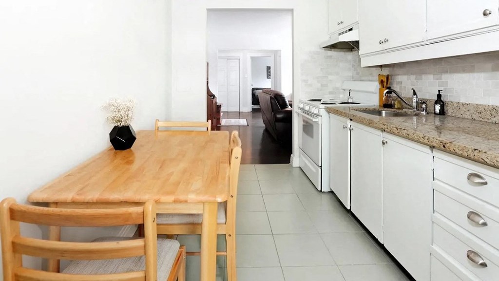 a kitchen with a wooden table and white cabinets