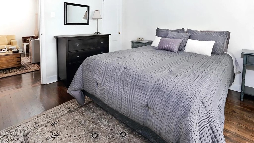 a bedroom with a bed and a black dresser