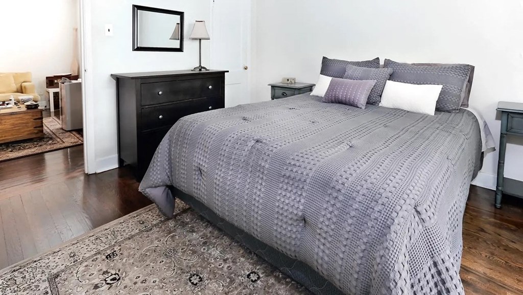 a bedroom with a bed and a black dresser