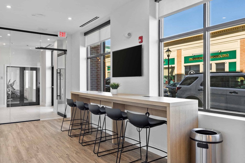 a kitchen with a counter and chairs in front of a window