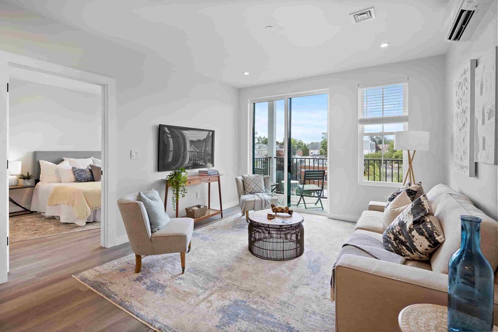 a living room with a couch and chairs and a tv