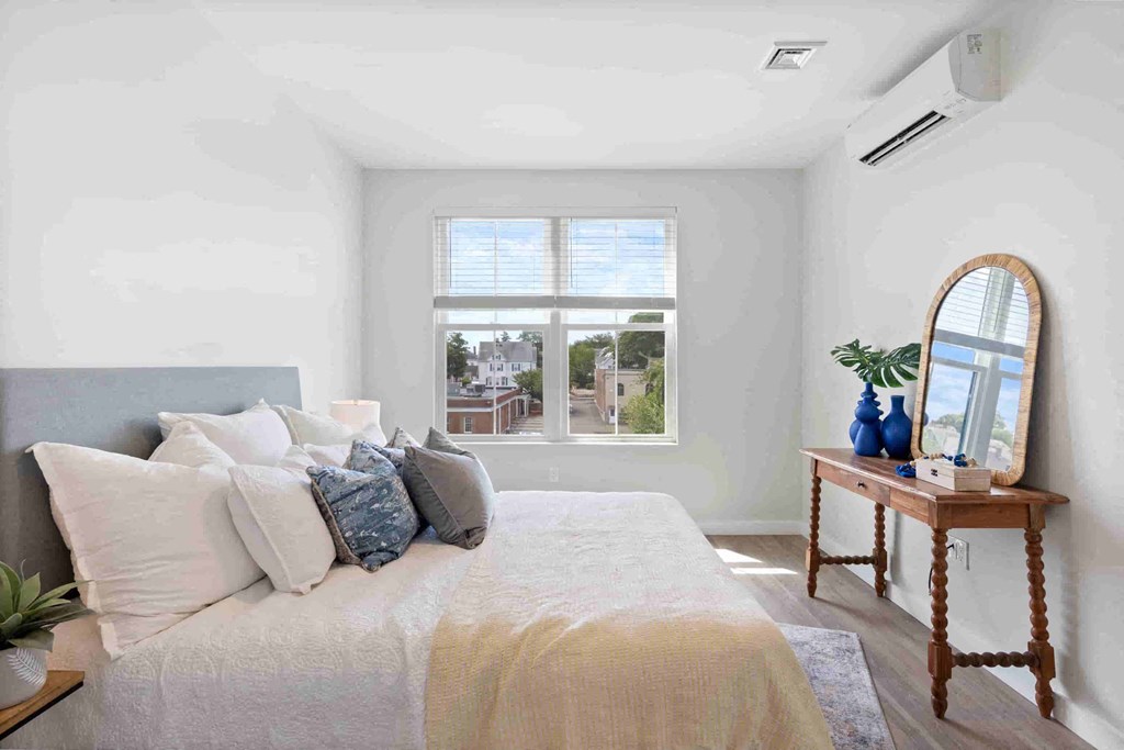 a bedroom with a bed and a large window