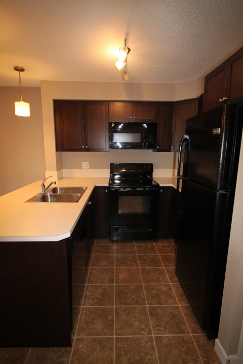 a kitchen with black appliances and white counter tops