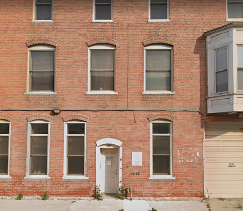 the front of a brick building with a white door