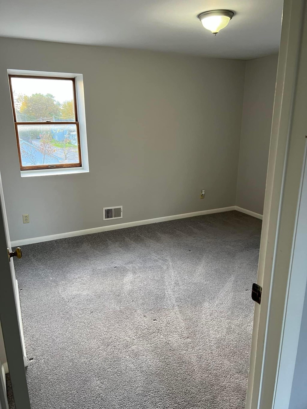 a room with a carpeted floor and a window