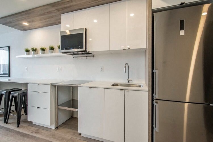 a kitchen with white cabinets and a stainless steel refrigerator