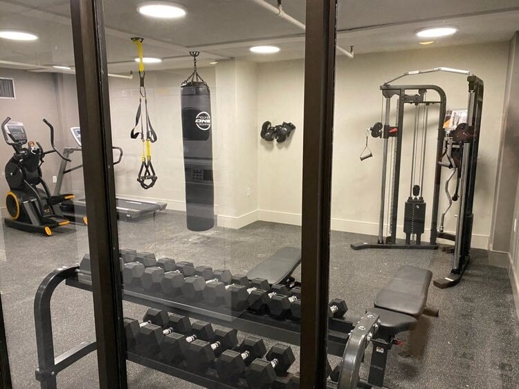 a gym with weights and a punching bag in it