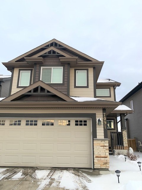 a house with a garage door in the snow