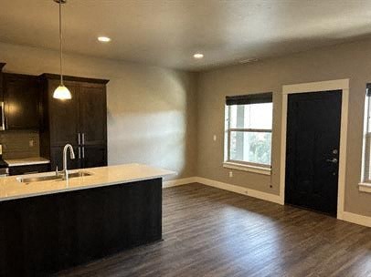 A kitchen with dark wood cabinets and a light-colored countertop.