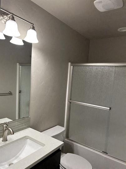 A bathroom with a sink, mirror, and shower.