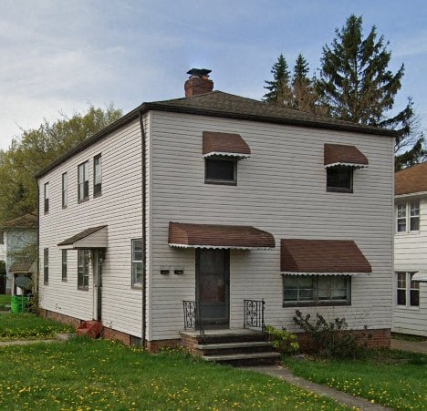 a white house with a door and a porch