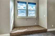 A room with a window and a carpeted floor.