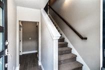 A staircase with a black handrail and wooden steps.