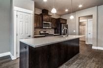 A kitchen with dark wood cabinets and a white countertop.