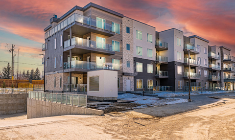 Apartment building with a sunset in the background.