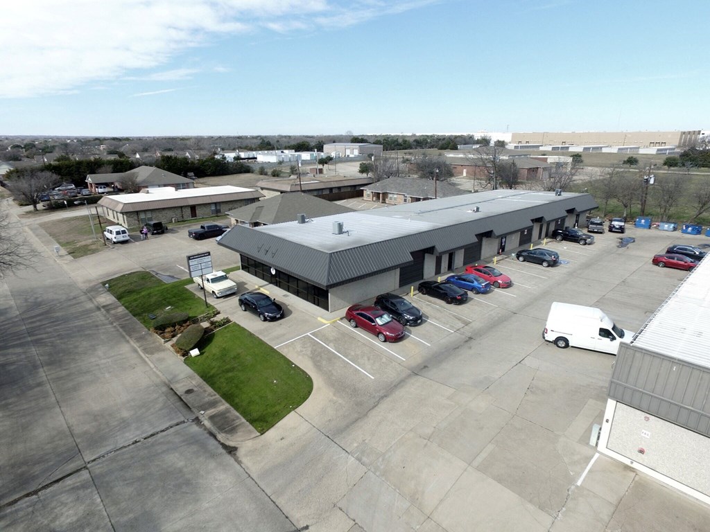 an aerial view of a parking lot and a building with cars parked
