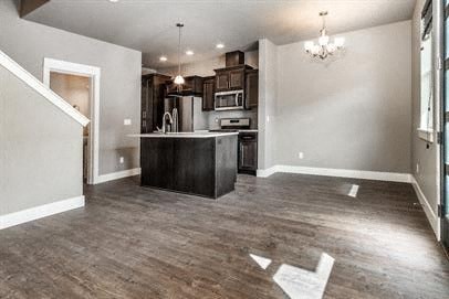 an empty living room with a kitchen and a