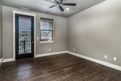 an empty living room with a ceiling fan and a door