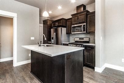 a kitchen with a white counter top and wooden cabinets