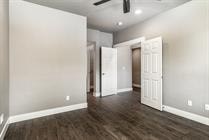 A room with a wooden floor and a ceiling fan.