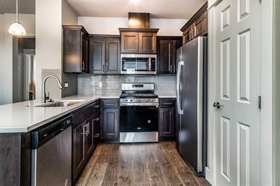 A modern kitchen with dark wood cabinets and stainless steel appliances.