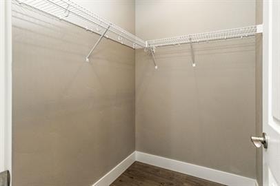 A white closet with a door and a shelf.
