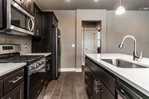 A kitchen with black cabinets and white countertops.