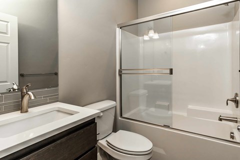 A white toilet sits next to a sink in a modern bathroom.