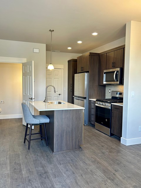 A kitchen with a bar stool and a counter.