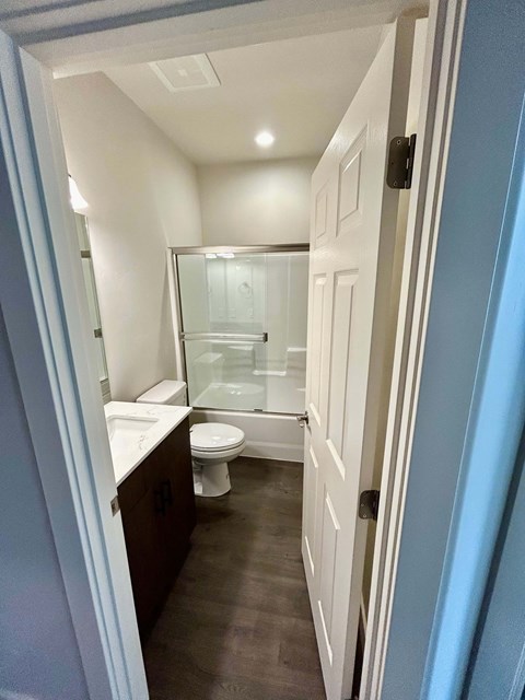 A bathroom with a toilet, sink and shower.