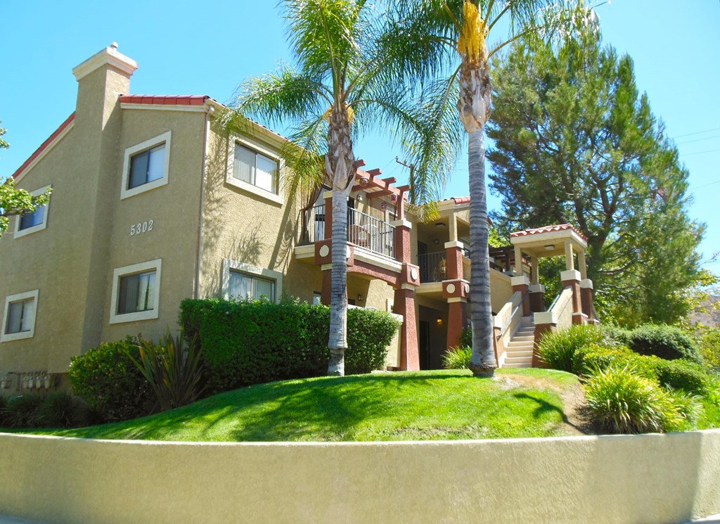 an apartment building with palm trees in front of it