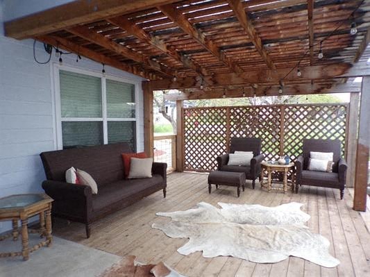 a patio with a wooden roof and furniture on it