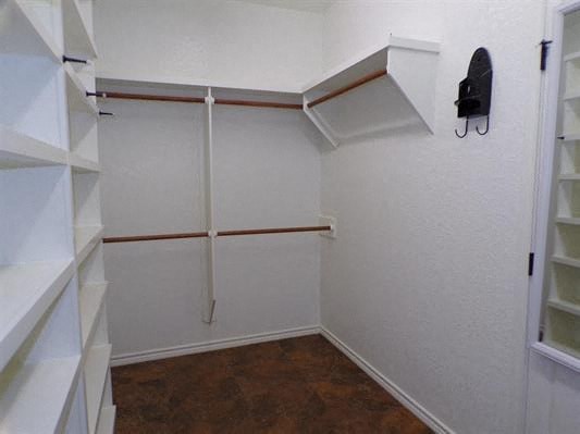 a white closet with shelves and a telephone in it