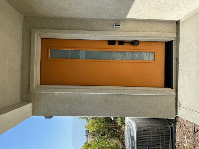 a window with an orange door and a fan