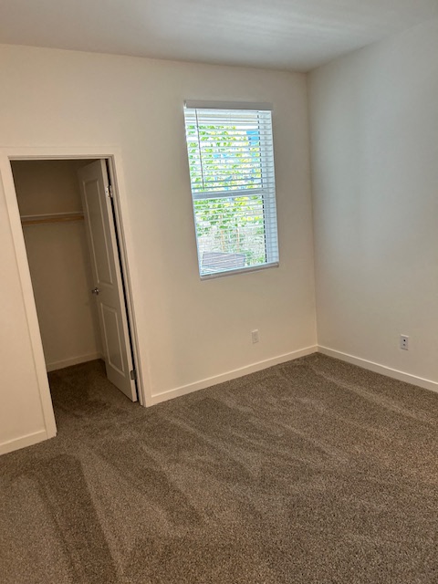 an empty room with a window and a closet