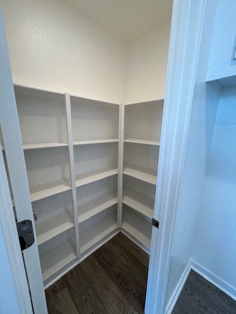 a closet with white shelves and a door