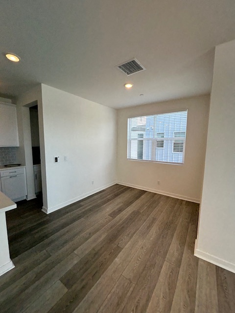 an empty living room with wood floors and a window